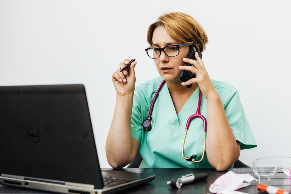 Healthcare professional checking a phone — social media monitoring for adverse drug reactions is a 24/7 job
