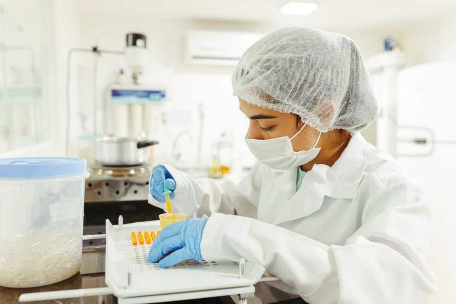 Laboratory scientist at work — flagged ADR signals from social media feed into the formal pharmacovigilance assessment process