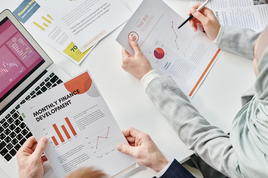 Finance reports and documents on a desk - the manual reporting workload AI automation removes
