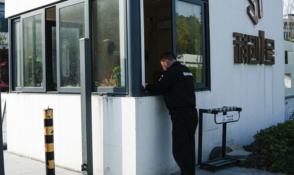 A security guard at an entrance booth checking arrivals, the real-world equivalent of Oracle valid node checking