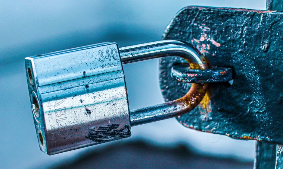 A hardened padlock securing a metal gate latch, representing Oracle listener hardening on port 1521