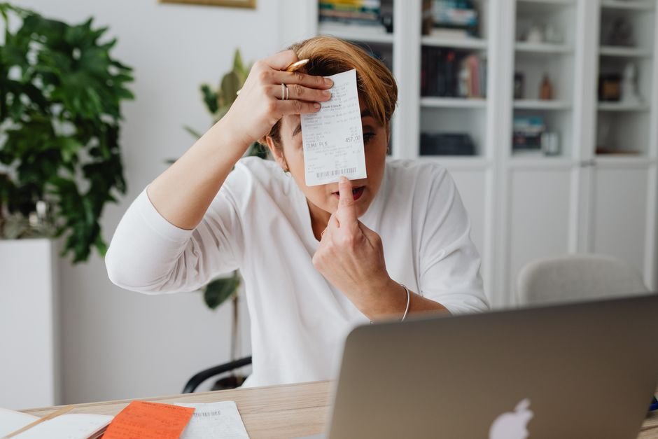 Business owner at a laptop reviewing invoices โ build versus buy moderation cost