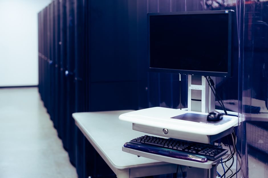 Computer beside server racks - local server hardware for running LLMs with Ollama on-premise