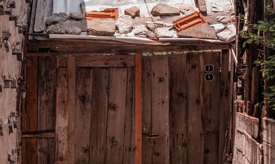A closed wooden gate in a narrow stone passage - the reverse proxy blocking an oversized APEX upload before it reaches ORDS