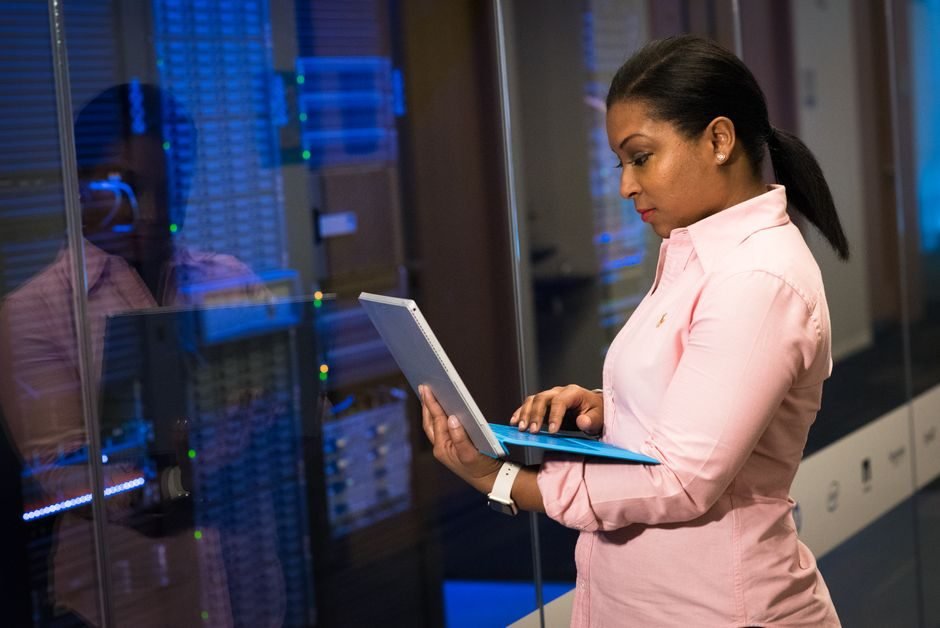 Engineer with a laptop in a server room, checking an Oracle database after a parallel execution parameter change