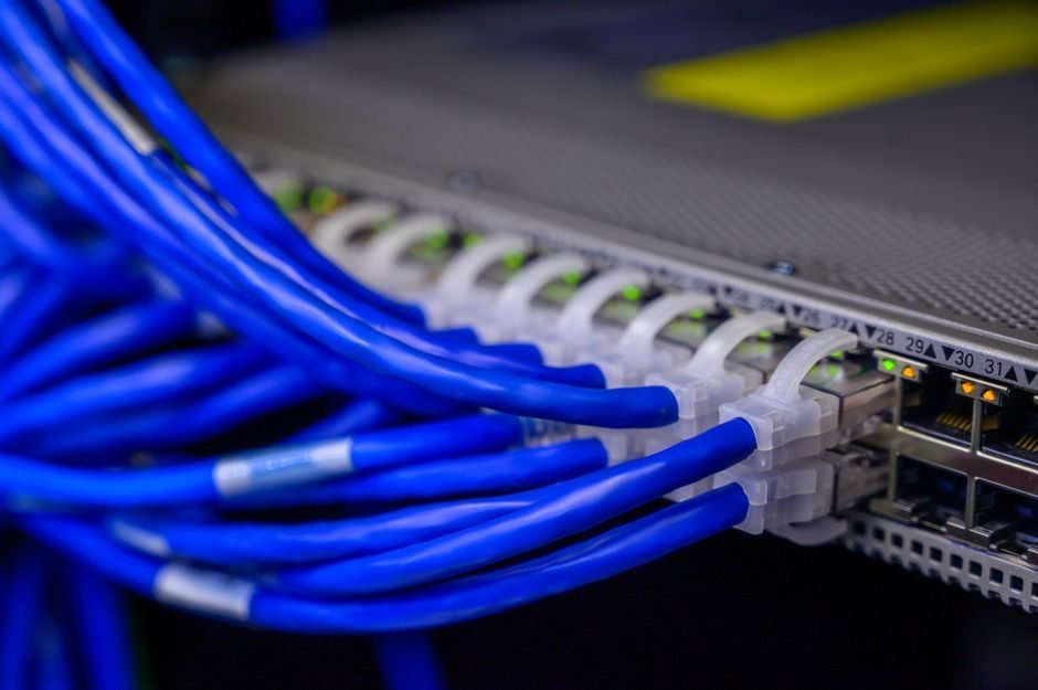 Network cables plugged into a server patch panel, representing the interconnect that Oracle PX server messages cross in a RAC cluster