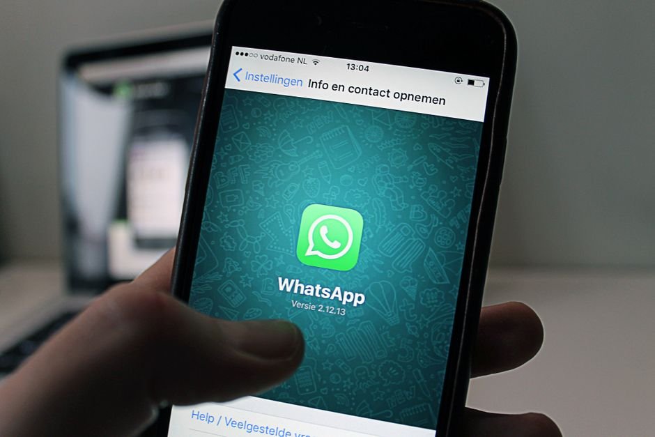 WhatsApp chat conversation open on a smartphone held in a customer's hand